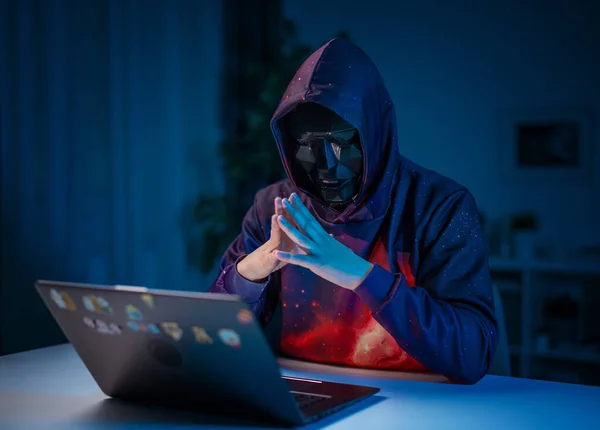 Haker w masce pracy na laptopie — Zdjęcie stockowe
