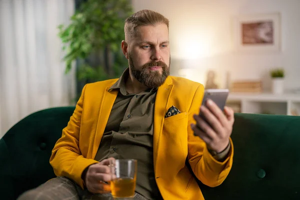 Mann auf Couch mit Smartphone — Stockfoto