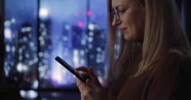 Yağmurlu gecelerde cep telefonu kullanan kadın