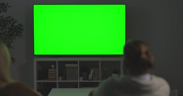 Familie op zoek naar groen scherm TV — Stockvideo