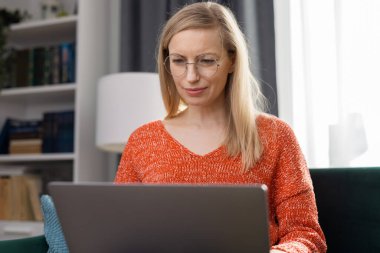 Evde Dizüstü bilgisayar kullanan kadın