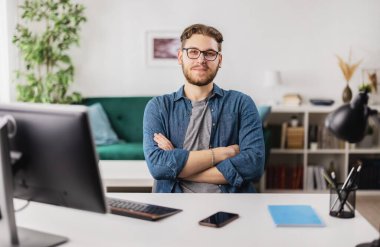 Evdeki adam dizüstü bilgisayarla çalışıyor.