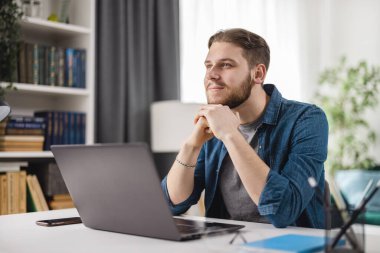 Evde dizüstü bilgisayarı olan hayalperest adam.