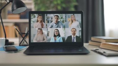 Modern taşınabilir dizüstü bilgisayar, bir grup şirket erkek ve kadın iş arkadaşı video aracılığıyla konuşuyor. İş ekibiyle bilgisayar ekranı.