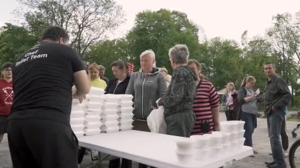 ボロディアンカ ウクライナ 2022年5月15日 ロシア占領から解放された後 男性ボランティアがウクライナ人に昼食用の箱をテーブルに置く 避難所に隠れている人々を養うという概念 — ストック動画