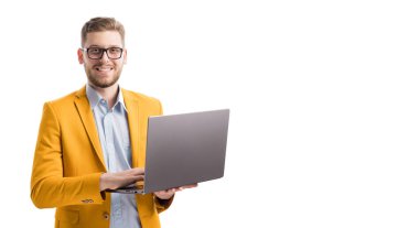 Stüdyoda kablosuz dizüstü bilgisayarın klavyesinde yazan güler yüzlü beyaz girişimci. Çevrimiçi projeyi kontrol eden neşeli erkek portresi. Boşluğu beyaz arkaplan üzerine kopyala.