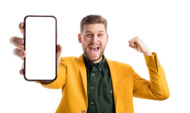 Neşeli erkek, boş boş alanı olan bir alet gösterirken, kazanan jest yapıyor. Zarif giyinen gülümseyen adam beyaz stüdyoda bir şey reklamını yapıyor..