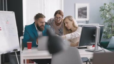 Kafkasyalı orta yaşlı meslektaşlar modern dizüstü bilgisayar ve bilgisayar üzerinde şirket uygulaması üzerinde çalışıyorlar. Modern ofiste toplantı sırasında iş adamları.