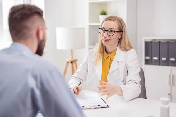 Woman psychologist consult man paient about health care, bright clinic office