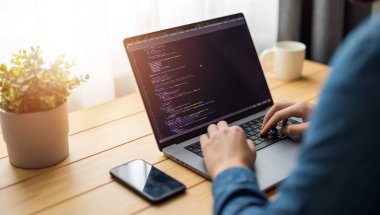 Bilgisayarda kod yazan, kod yazan, uzaktan kumandalı bir adam.