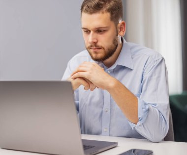 Genç düşünceli iş adamı dizüstü bilgisayarda çalışıyor, düşüncelerini kendine sakla.