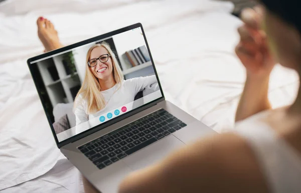 ノートパソコンの画面表示 ビデオチャットアプリケーションを使用して自宅から話している実業家 会話が楽しい熟女さん 肩を撃たれた — ストック写真