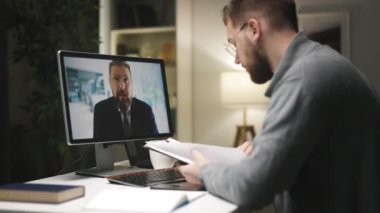 İki erkek işadamının video kaset ve silikonlu iş yerleri var ve bilgileri gazetelerden kontrol ediyorlar..