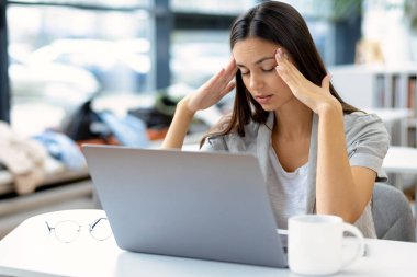 Yorgun, beyaz kadın portresi. İş yerinde kendini kötü hissediyor. Ağrı, depresyon, aşırı çalışma konsepti.