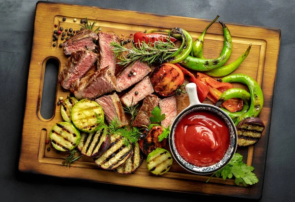 Krájené Smažené Střední Steak Grilovanou Zeleninou Kečup Omáčkou Dřevěné Řezací — Stock fotografie