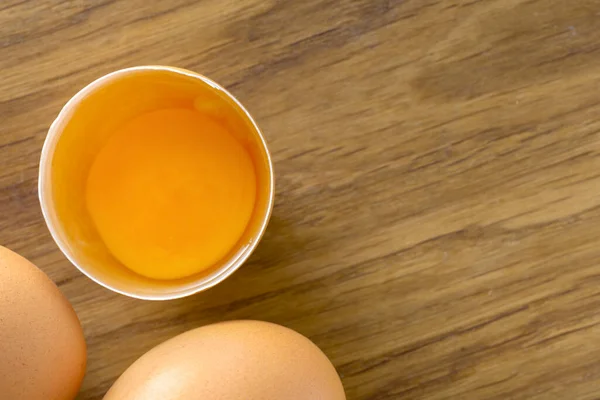 Top View Broken Brown Raw Egg Whole Eggs Wooden Background — ストック写真