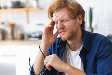 Close up portrait of tired stressed Caucasian man having headache feeling sick, pain, depression, overwork concept