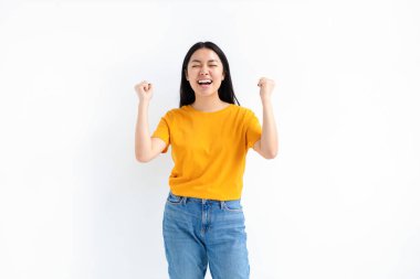 Joyful Asian woman rejoicing, say yes, looking happy and celebrating victory standing over white background, winner concept