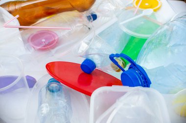 Ecology concept. Multicolored plastic trash on white background.
