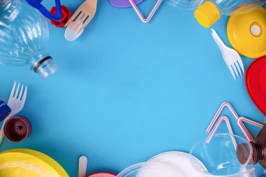 Reuse garbage, recycle, plastic free. Multicolored plastic trash on a blue background. Ecology concept. Copy space. Recycling plastic.