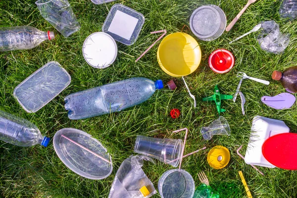 Reuse garbage, recycle, plastic free. Food plastic packaging, trash on green grass background. Recycling plastic. Environmental pollution, ecology concept