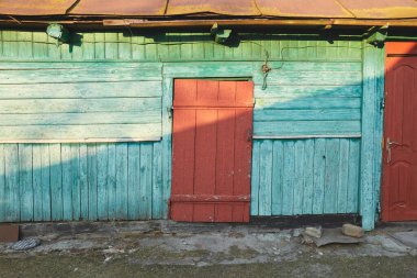 Ahşap kırmızı kapı ve Ukrayna 'nın gölgesinde yeşil duvar.