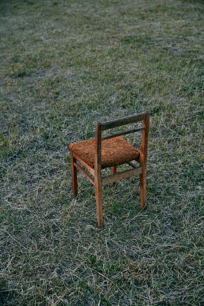 Uma Cadeira Madeira Com Estofos Castanhos Fica Pôr Sol Campo — Fotografia de Stock