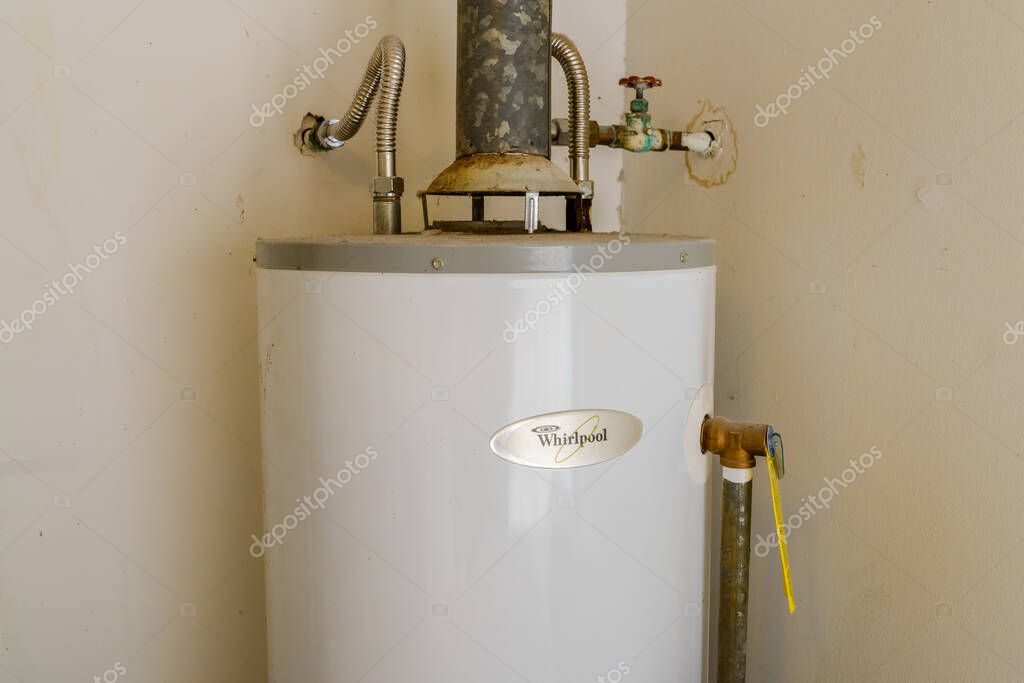 NEW ORLEANS, LA, USA - SEPTEMBER 17, 2022: Upper third of an old but operational Whirlpool conventional hot water heater in the corner of a shed