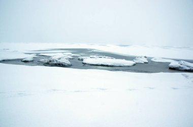 Minimalist kış deniz manzarası ve donmuş sulardaki gladyatörler