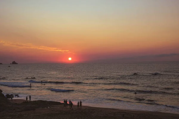 Kumsalda gün batımı güzel turuncu ve deniz mavisi renkleriyle