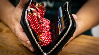 Black leather wallet with smart watch on the wooden table 