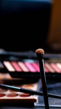 makyaj fırçaları ve siyah arkaplanda göz gölgeleri