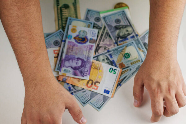 man hand holding a bunch of dollars in the background