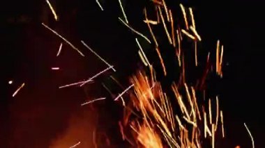 Kıvılcımlar siyah bir arka planda uçuşuyor ve dumanla