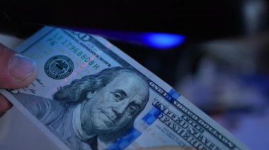 Ultraviyole ışıkta para. Konsept - doğruluk için dolar kontrolü. Banknotlardaki filigranları ara.