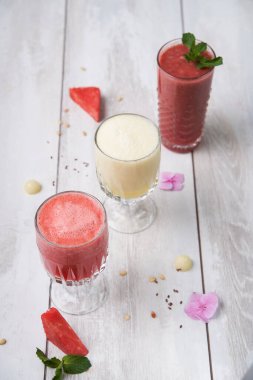 Kahvaltı için üç farklı meyve suyu tabağı. Taze, sulu, organik meyve dönüşümlü, ahşap bir arka planda yaz içeceği.