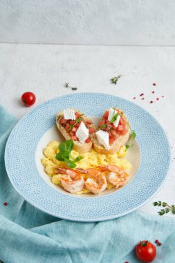 Karidesli omlet ve mavi tabakta bruschetta.