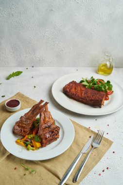 Izgara ve füme pirzola, barbekü sosu ve salata.