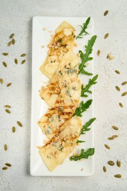 Beyaz arka planda peynirli kavun salatası ve Arugula.