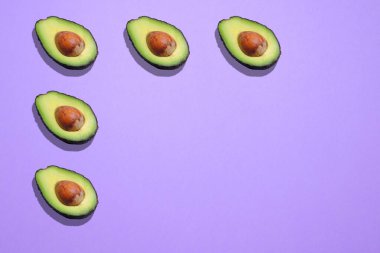 Avokadoların mor arkaplan üzerindeki köşesi.