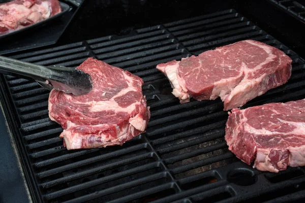 A grelhar carne fresca. Bifes grelhados em grelha flamejante — Fotografia de Stock