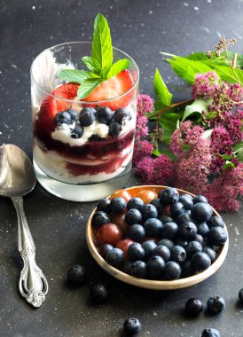 Meyve salatası ve taze böğürtlenli doğal Yunan yoğurdu. Sağlıklı yeme kavramı. 