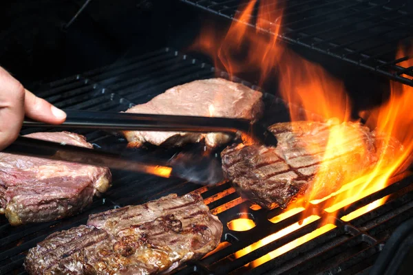 Griller les steaks sur le gril enflammé. Cuisiner dehors — Photo