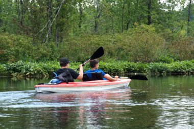 Nehirde kayak yaparken. Su sporları ve yaz tatili teması.