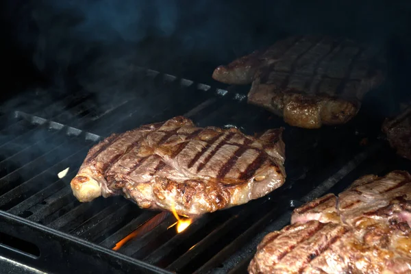 Fresh grilled meat, beef or pork. Grilling steaks on flaming grill — Fotografia de Stock