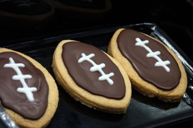 Super Bowl parti kurabiyeleri. Futbol şeklinde kurabiyeler. Ev yapımı kurabiye konsepti. 