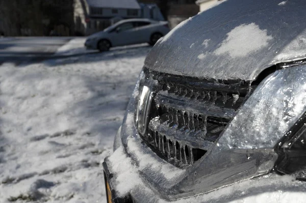 Vista de primer plano del frente del coche cubierto de hielo durante la tormenta de invierno. Enfoque selectivo — Foto de Stock