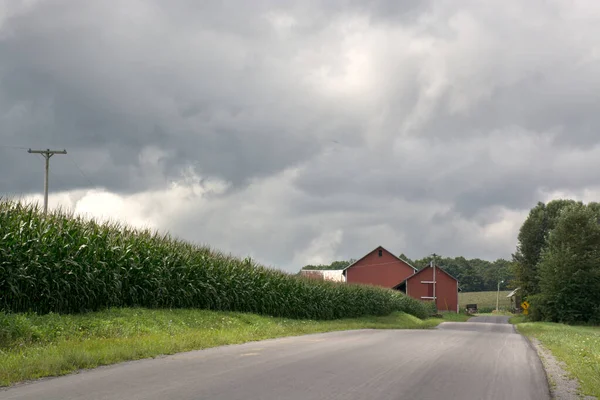 Camino al campo americano. Dramático cielo tormentoso sobre la carretera del campo. — Foto de Stock
