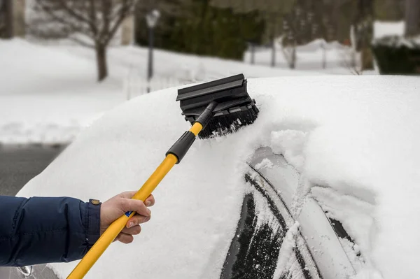 La persona quita la nieve del coche. Tormenta de nieve. — Foto de Stock