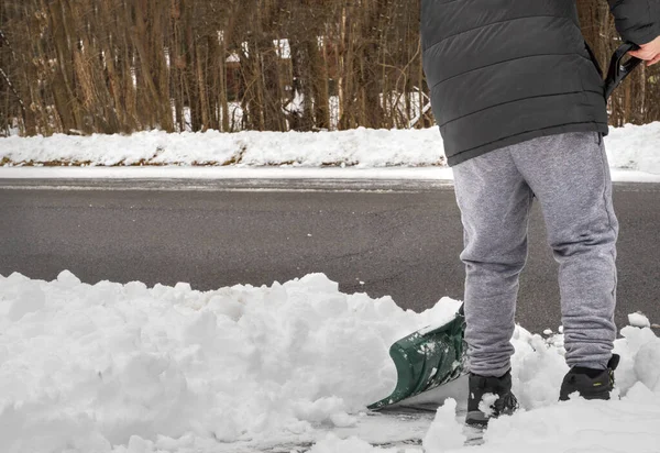 雪のシャベルを持つ男は冬に歩道をきれいにする。冬の仕事 — ストック写真